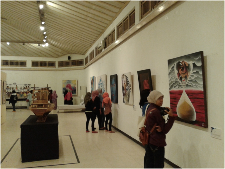 Pengunjung sedang menikmati karya seni lukisan yang di tampilkan di perfoming art di Art Edu Care #5 (Foto diambil oleh: Hamdan N.)